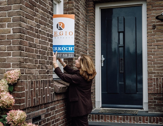 Makelaar van Regio Makelaars plaatst verkocht-bord bij woning in Nieuw-Vennep