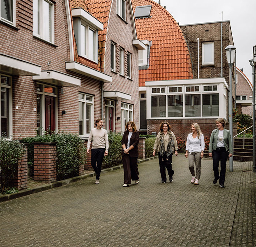 Team Regio Makelaars lopend door straat met woningen