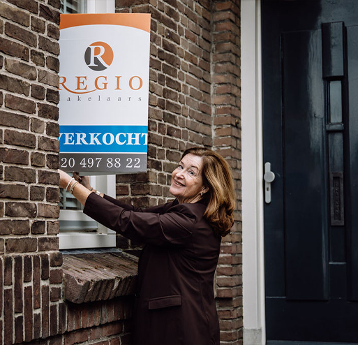 makelaar gaat woning verkopen en plakt verkoopbord