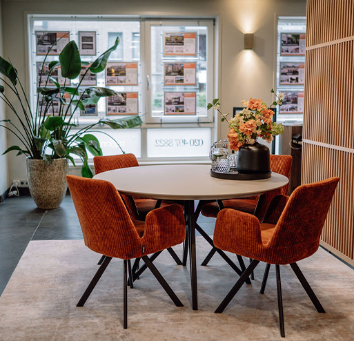 kantoor van regio makelaar met oranje stoelen en ronde tafel